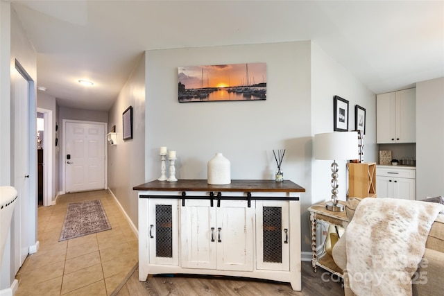 kitchen featuring light tile patterned floors, white cabinetry, and baseboards