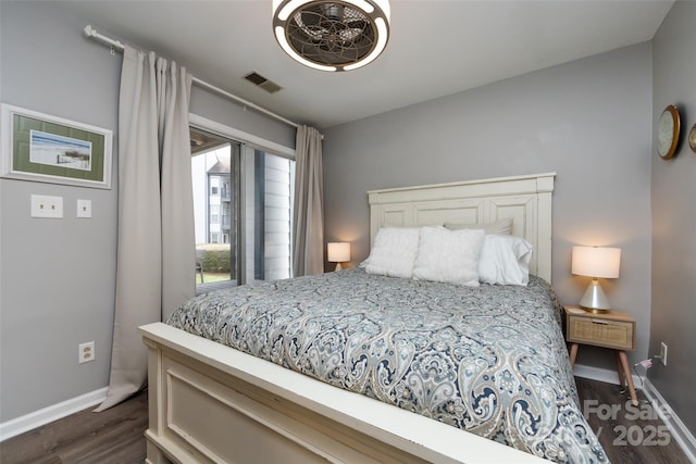 bedroom with dark wood-style floors, visible vents, and baseboards