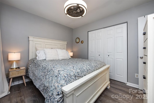 bedroom with dark wood-type flooring, a closet, and baseboards