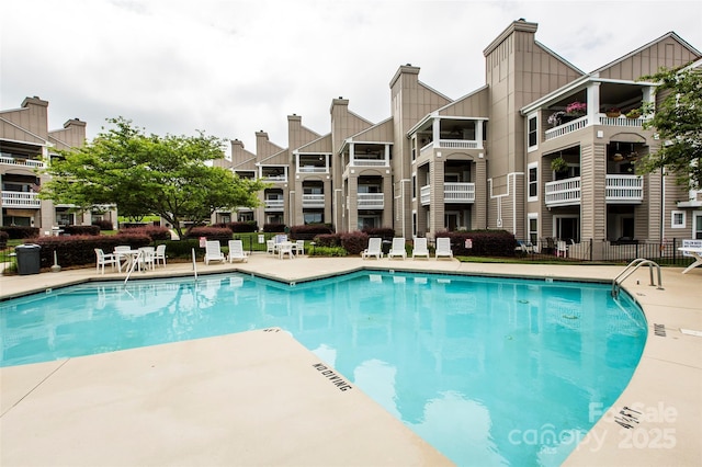 pool featuring fence and a patio