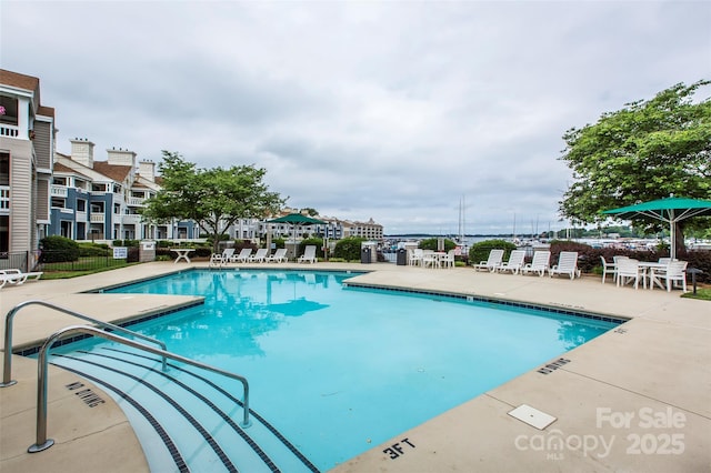 pool with a patio area and fence