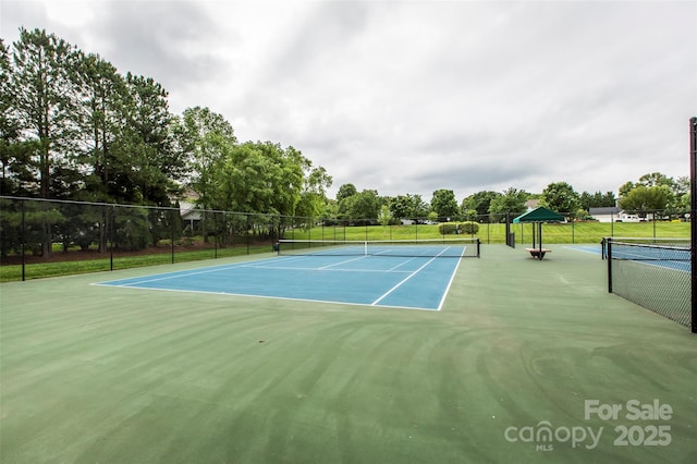 view of tennis court featuring fence