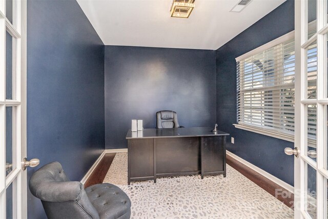 office with french doors, visible vents, baseboards, and wood finished floors