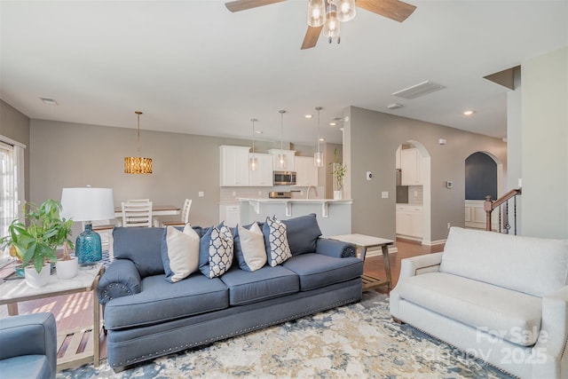 living room with visible vents, arched walkways, ceiling fan, and recessed lighting