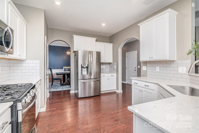 kitchen featuring white cabinets, dark wood-style floors, stainless steel appliances, and a sink