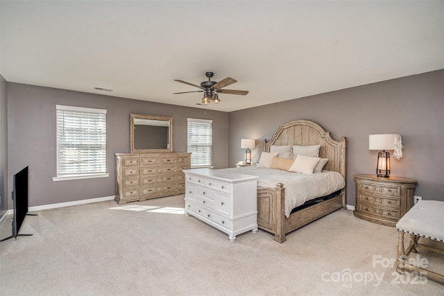 bedroom with light carpet, ceiling fan, visible vents, and baseboards