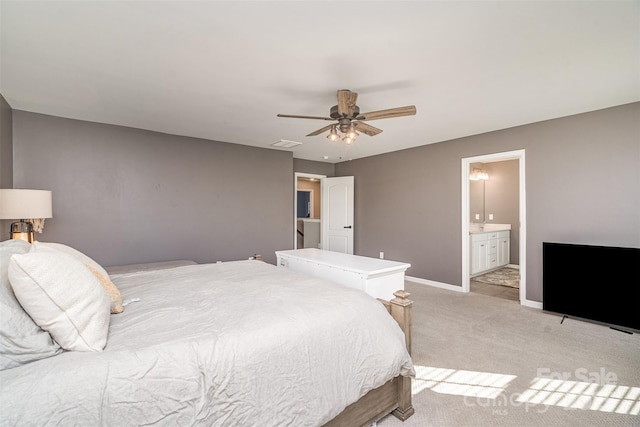 bedroom featuring ceiling fan, light colored carpet, visible vents, baseboards, and ensuite bath