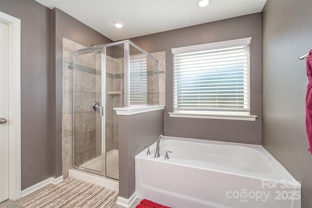 bathroom with a stall shower and a garden tub