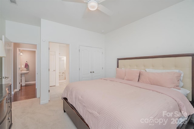 bedroom with baseboards, visible vents, a ceiling fan, light colored carpet, and a closet