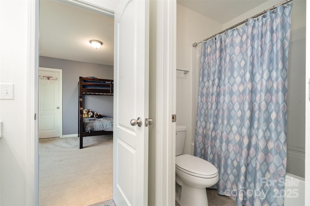 bathroom featuring a shower with shower curtain and toilet