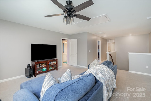 living area featuring light carpet, attic access, and baseboards