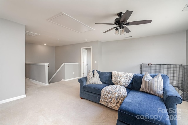 living area with attic access, visible vents, carpet floors, and baseboards