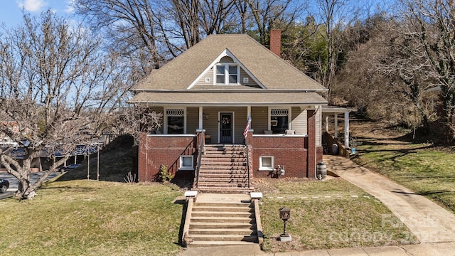 view of front facade featuring stairs, a porch, a front yard, and brick siding