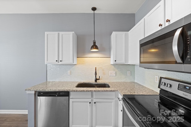 kitchen with stainless steel appliances, backsplash, a sink, and white cabinets