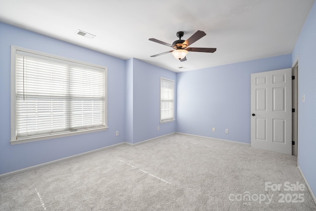 empty room featuring baseboards, carpet, visible vents, and a ceiling fan