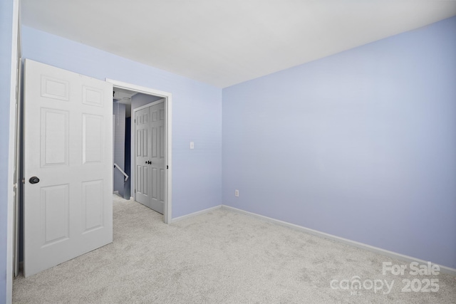 empty room featuring carpet and baseboards