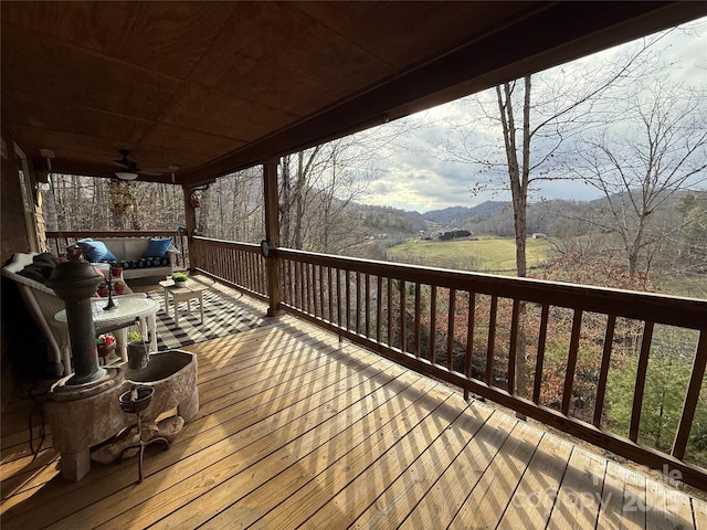 deck featuring a mountain view and ceiling fan