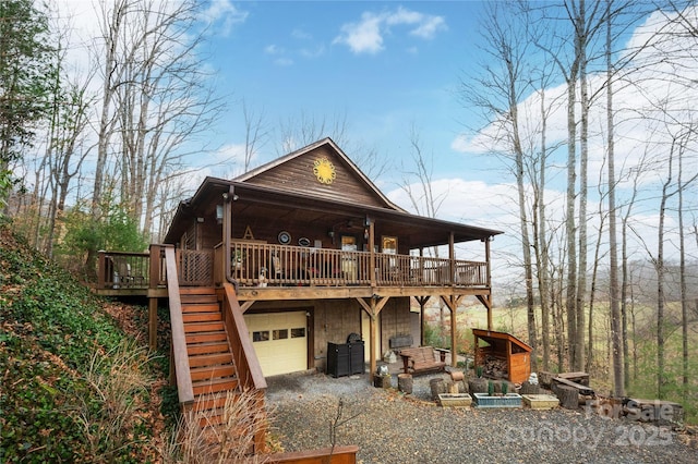 exterior space with driveway, stairway, an attached garage, and a wooden deck