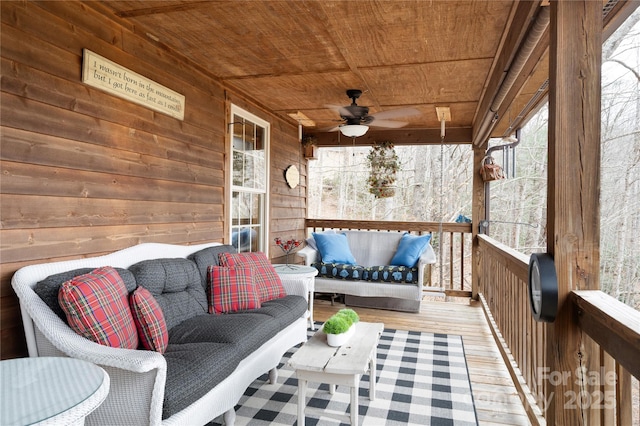 wooden deck featuring outdoor lounge area and a ceiling fan