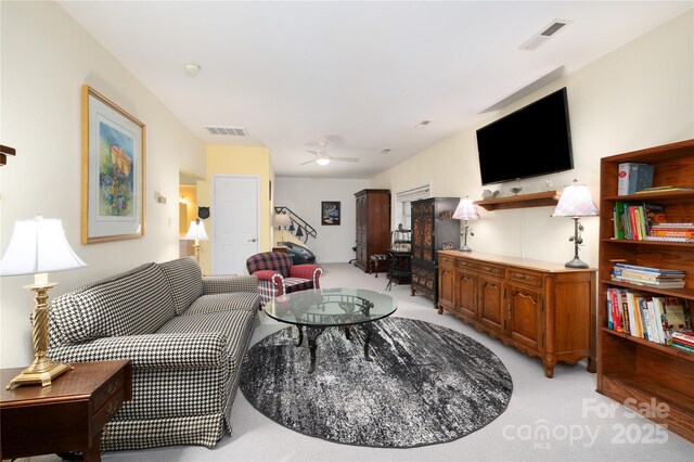 living room with visible vents, light carpet, and a ceiling fan