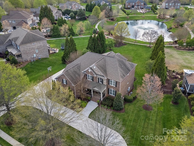 birds eye view of property with a water view and a residential view