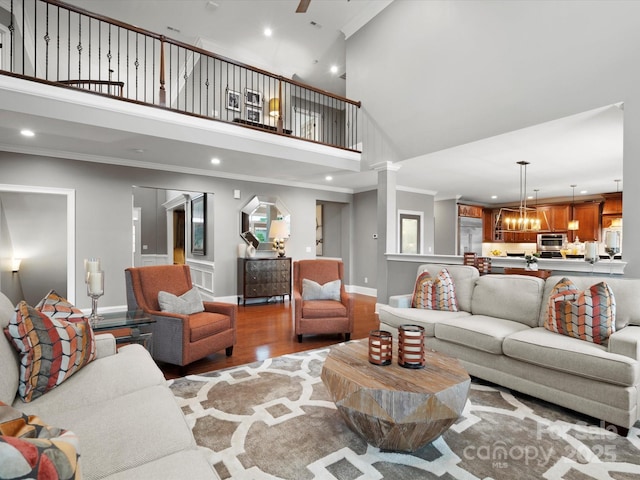 living room featuring crown molding, baseboards, light wood finished floors, and recessed lighting