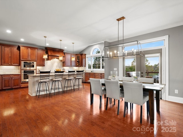 dining area featuring an inviting chandelier, recessed lighting, dark wood-style flooring, lofted ceiling, and baseboards