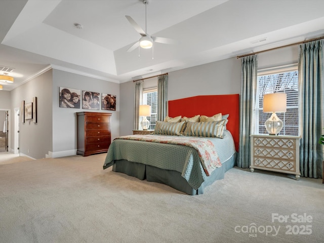 carpeted bedroom with ceiling fan, ornamental molding, visible vents, a raised ceiling, and baseboards