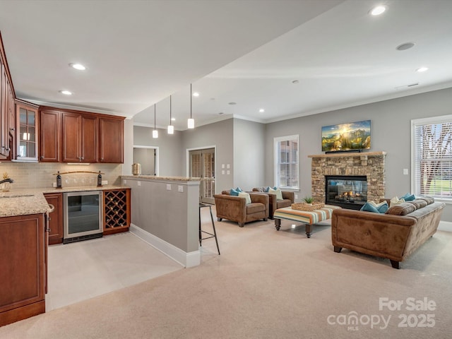 kitchen with a peninsula, light colored carpet, beverage cooler, and glass insert cabinets