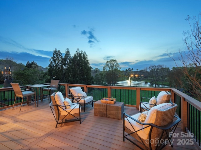 wooden terrace with an outdoor hangout area and a water view