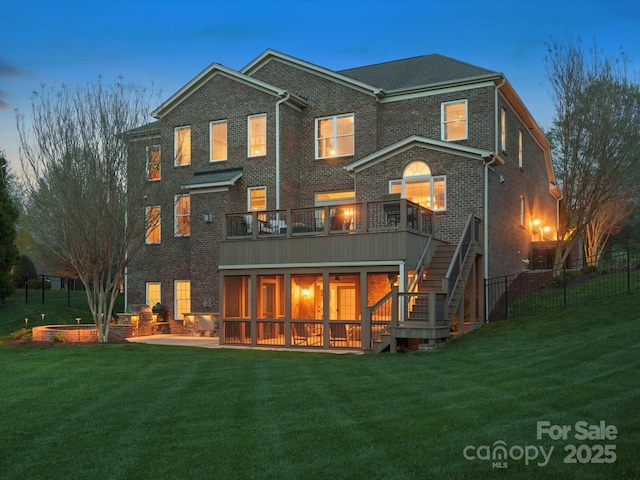 rear view of house featuring a yard, brick siding, stairs, and a patio area