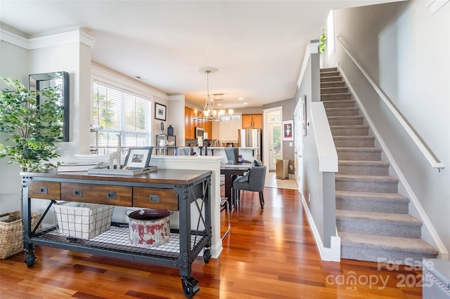 interior space featuring a chandelier, wood finished floors, stairs, and baseboards