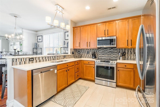 kitchen featuring a chandelier, stainless steel appliances, a peninsula, a sink, and visible vents