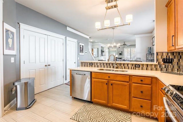 kitchen featuring a peninsula, appliances with stainless steel finishes, a sink, and brown cabinets