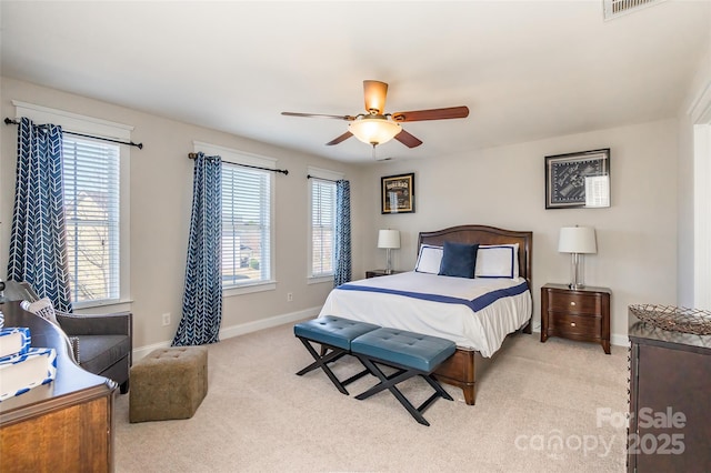 bedroom with a ceiling fan, light carpet, and baseboards