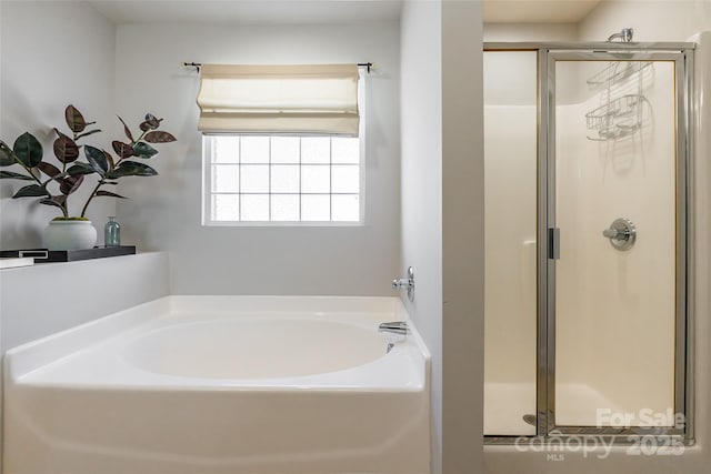 full bathroom featuring a stall shower and a bath