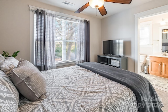 bedroom with connected bathroom, visible vents, and a sink