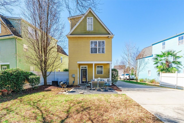 view of front of property featuring central AC, a front lawn, a patio area, and fence