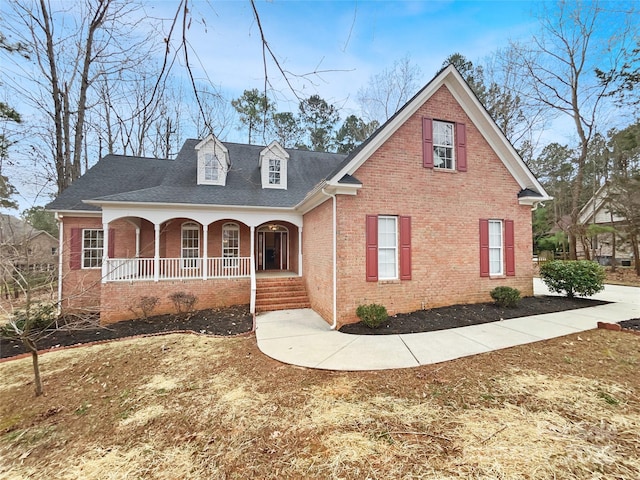 view of front of house with a porch and brick siding