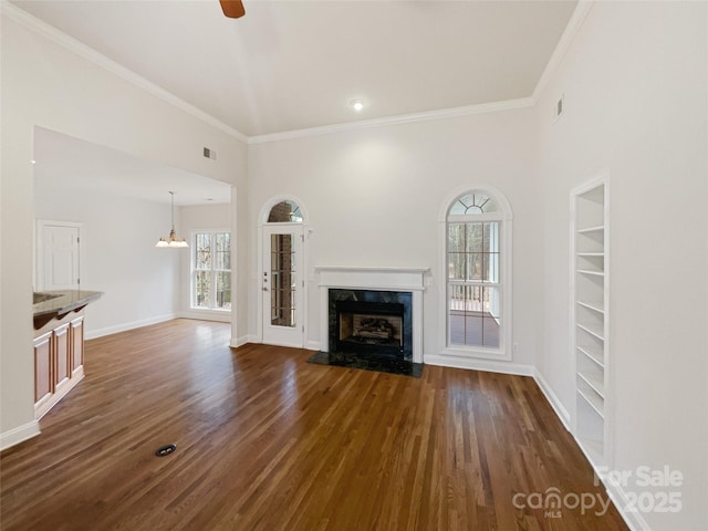 unfurnished living room with dark wood-style floors, baseboards, a premium fireplace, and built in features