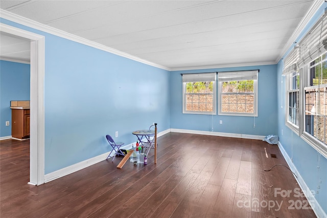 empty room with hardwood / wood-style flooring, baseboards, and ornamental molding