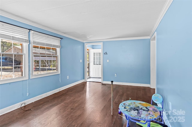 spare room featuring baseboards, ornamental molding, and hardwood / wood-style floors