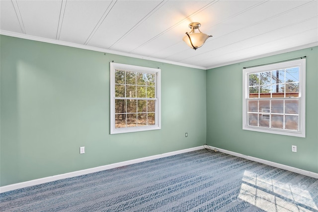 empty room featuring carpet, baseboards, and crown molding