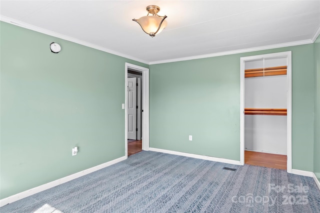 unfurnished bedroom with ornamental molding, a closet, carpet, and baseboards