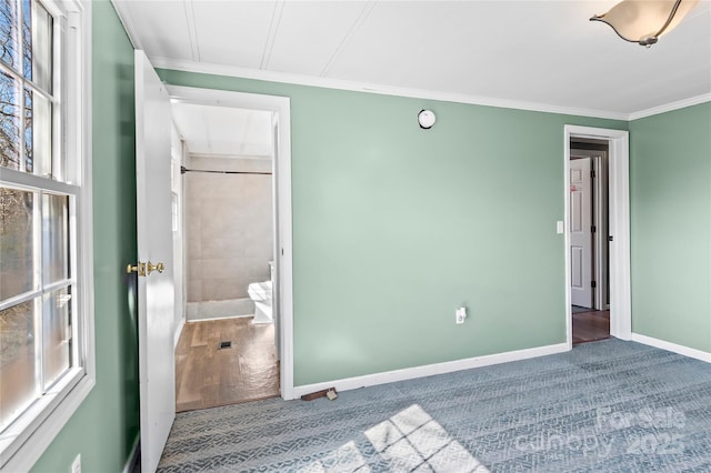 unfurnished bedroom with ornamental molding, carpet, and baseboards