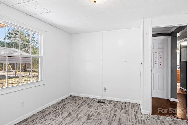 unfurnished room with baseboards