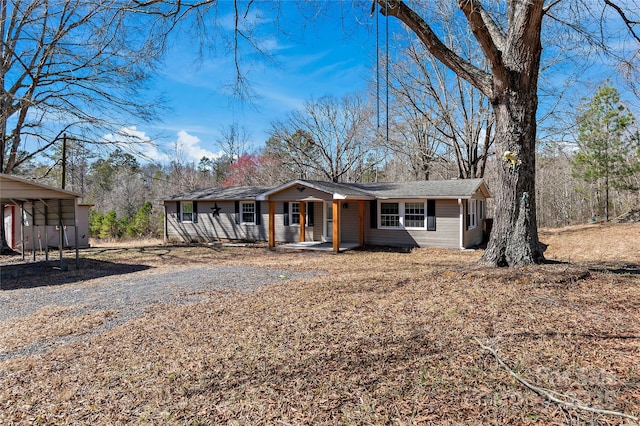 single story home with driveway and a porch