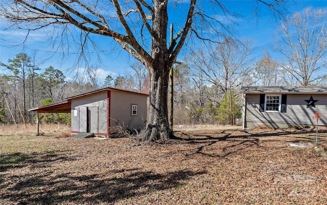 view of yard with an outbuilding and an attached carport