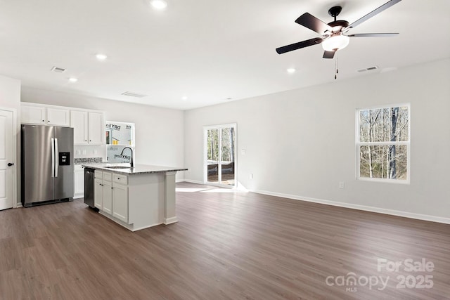 kitchen with white cabinets, stainless steel appliances, dark wood finished floors, and open floor plan