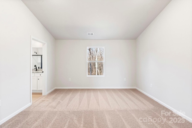 empty room with light colored carpet, visible vents, and baseboards